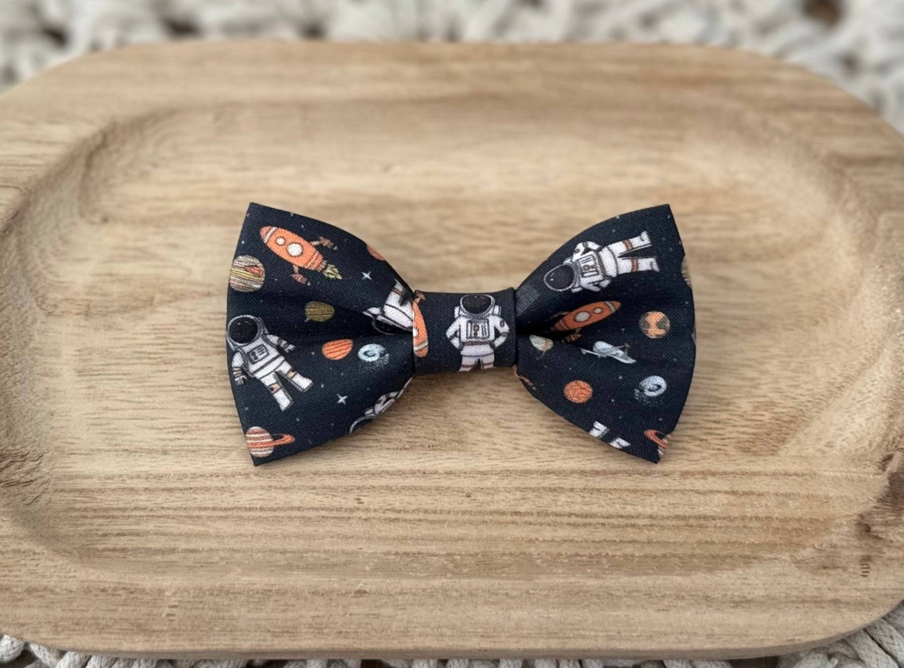 A space-themed bow tie with astronauts, spaceships and planets