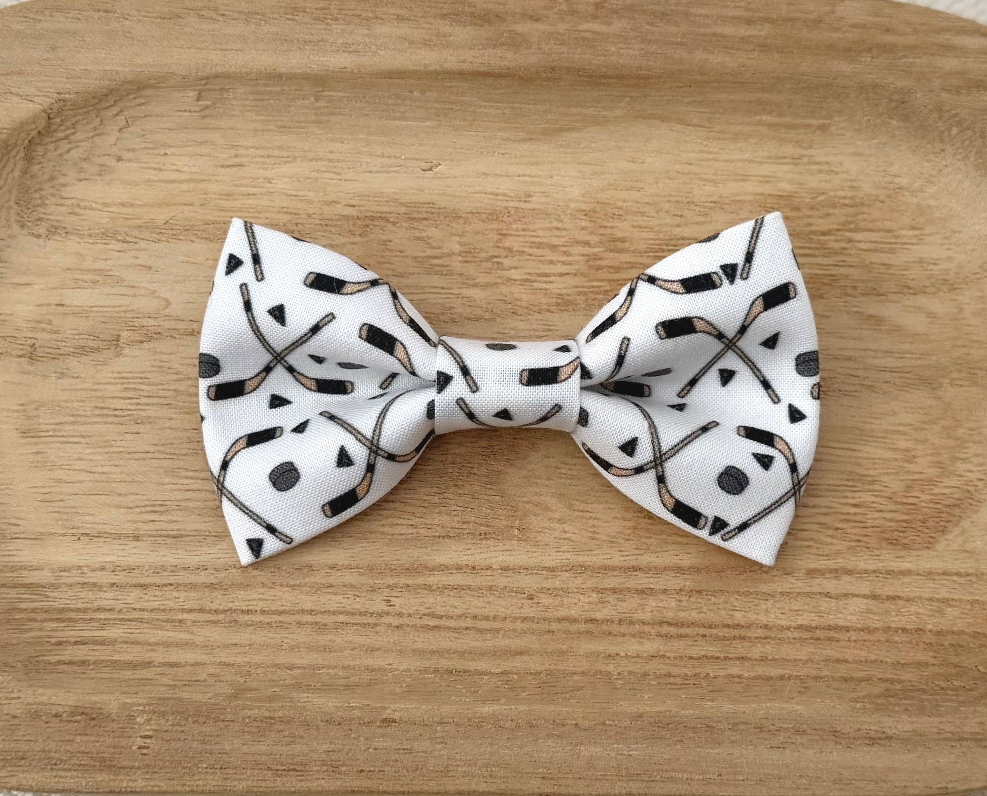 White bow tie with black Hockey Sticks and Hockey Pucks
